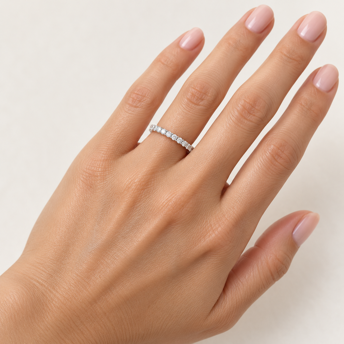 Round two-prong lab-grown diamond eternity band, 1.5 mm diamonds, white metal, hand view