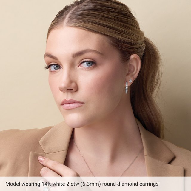 Model wearing 14K white gold 2 CTW round diamond stud earrings — on-ear size reference